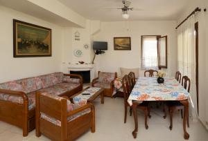 a living room with a couch and a table and chairs at Seabreeze Platanidia in Platanidia