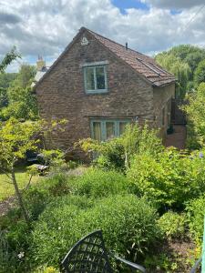a brick house with a window in a garden at Little Llanvolda in Saint Maughans