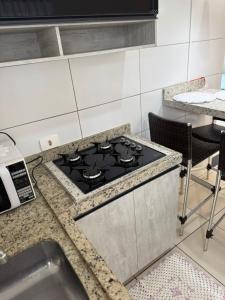 a kitchen with a stove top oven next to a sink at Apartamento maringa in Maringá