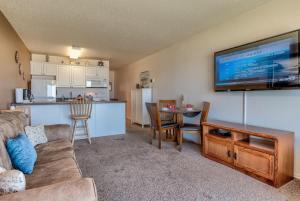 a living room with a couch and a flat screen tv at Ground Floor Beachfront Condo Suite - Pool And Sauna in Lincoln City