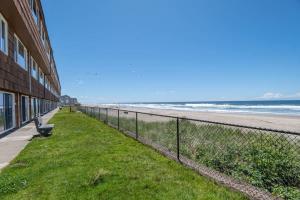 a chain link fence next to the beach at Ground Floor Beachfront Condo Suite - Pool And Sauna in Lincoln City