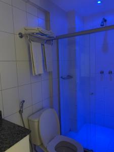 a bathroom with a toilet and a glass shower at Celita Franca Apart in Feira de Santana +36 photos