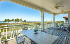 a porch with a table and chairs and the ocean at Serenity Sunset 5Bedroom Dog Friendly Beach House on St George Island in Eastpoint