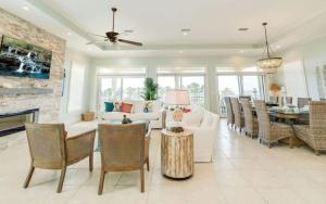 a living room with a white couch and a fireplace at Serenity Sunset 5Bedroom Dog Friendly Beach House on St George Island in Eastpoint