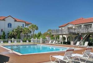 a swimming pool with chairs and a house at Serenity Sunset 5Bedroom Dog Friendly Beach House on St George Island in Eastpoint