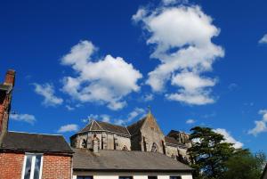 eine alte Kirche mit blauem Himmel und Wolken in der Unterkunft La Petite Maison, Perrou, Normandy, Orne in Perrou