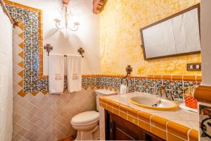 a bathroom with a toilet and a sink at Hotel El Descanso Cultural in Antigua Guatemala