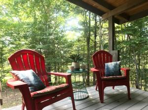 two red rocking chairs sitting on a porch at The Treehouse TN Honeymoon Cabin HOT TUB - in BSF! in Jamestown