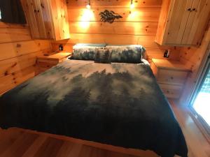 a bedroom with a bed in a wooden cabin at The Treehouse TN Honeymoon Cabin HOT TUB - in BSF! in Jamestown