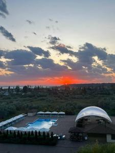 ザトカにあるApartments Promenad 2の夕日を背景にプールを望めます。