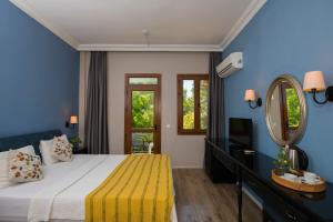 a bedroom with a large bed and a mirror at Akkent Garden Hotel in Fethiye +53 photos