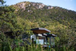 a house with a mountain in the background at Majulê Ecolodge in Cavalcante