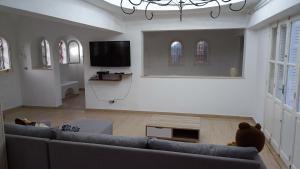 a living room with a couch and a flat screen tv at Maison Sérénité Campagne in Hammamet Sud