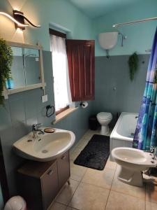Un baño con lavabo, inodoro y bañera. en Su Cracinaiu, en Teulada