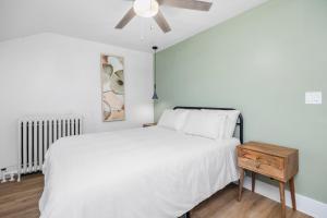 a bedroom with a white bed and a ceiling fan at Downtown Adams in Sandusky
