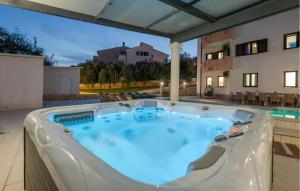 a hot tub on a patio with a building at Awesome Home In Pula With Sauna in Pula +56 photos