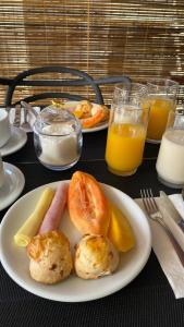 uma mesa com dois pratos de comida e sumo de laranja em Suítes Mucugê em Arraial d'Ajuda mais 25 fotografias