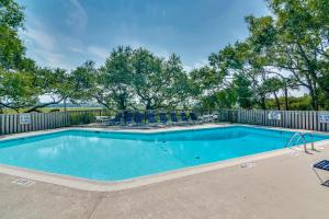 a swimming pool with chairs and a fence at Creekwatch 1245 in Seabrook Island