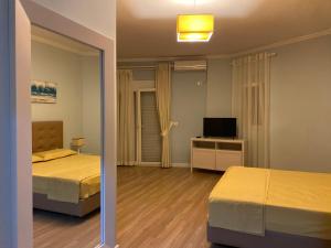 a bedroom with two beds and a television in it at Apartment in Primavera Residence in Fushë-Draç