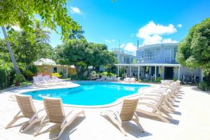 una piscina con sedie e un edificio di Grand Melanesian Resort Wailoaloa a Nadi
