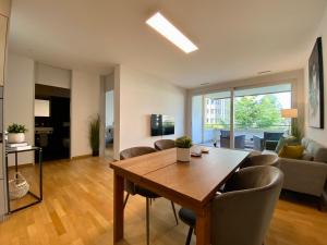 a living room with a wooden table and chairs at Stadtwohnung beim Albisriederplatz in Zürich