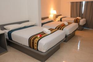 una camera d'albergo con tre posti letto di Grand Melanesian Resort Wailoaloa a Nadi Altre 36 foto