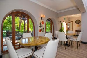 a dining room with a wooden table and white chairs at Akkent Garden Hotel in Fethiye
