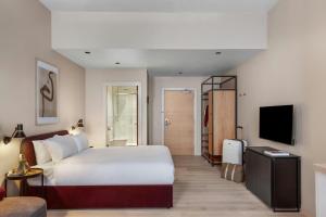 a hotel room with a bed and a television at VCity Suites at The Teacher in Glasgow
