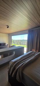 ein Schlafzimmer mit zwei Betten und einem großen Fenster in der Unterkunft Bangalô Kyalami Wake Park in Várzea Grande + 14 Fotos