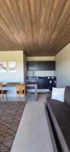 ein Wohnzimmer mit Couch und Tisch und eine Küche in der Unterkunft Bangalô Kyalami Wake Park in Várzea Grande