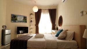 a bedroom with a large bed with a window at Royal Suites Muscat in Ma‘ābīlah