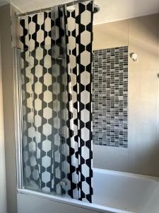a shower with a black and white shower curtain at Double Room in a 3-bed house in Havant