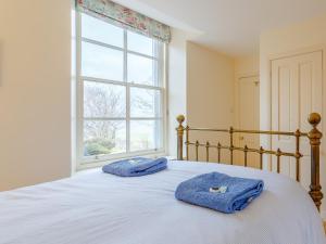 two towels on a bed in a bedroom with a window at 3 bed in Achnasheen CA120 in Inveralligin