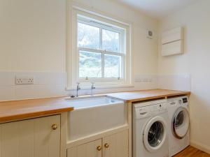 a kitchen with a sink and a washing machine at 3 bed in Achnasheen CA120 in Inveralligin