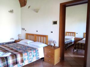 een slaapkamer met twee bedden en een spiegel bij Agriturismo Contessa Beatrice in San Vincenzo