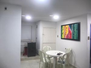 a table and chairs in a room with a painting on the wall at Hostal Jerry Inn in Valledupar +7 photos