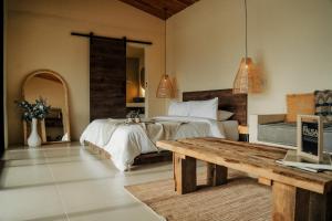 a bedroom with a bed and a wooden table at La Pausa Hotelbistro in Guatapé