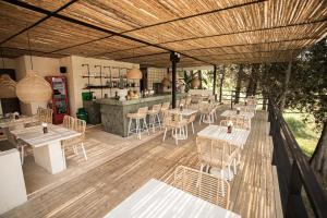a restaurant with tables and chairs on a wooden deck at La Pausa Hotelbistro in Guatapé
