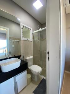a bathroom with a sink and a toilet and a shower at Duplex vista mar acomoda até 12 pessoas com piscina e estacionamento privativo in Canoa Quebrada