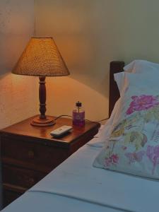 een lamp op een nachtkastje naast een bed bij Casa Ferradurinha & Geribá in Búzios