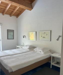a bedroom with a large bed with white sheets at Monte dos Pensamentos - Turismo Rural in Estremoz