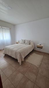 a white bedroom with a large bed and a rug at Las Lomitas in Lincoln