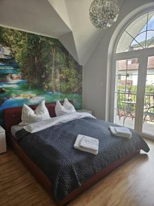 a bedroom with a large bed with a painting on the wall at Willa na Ogrodowej in Długopole-Zdrój
