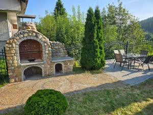 a patio with a stone fireplace in a yard at Willa na Ogrodowej in Długopole-Zdrój