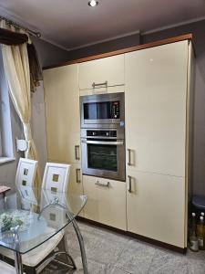 a kitchen with a glass table and a microwave at Willa na Ogrodowej in Długopole-Zdrój