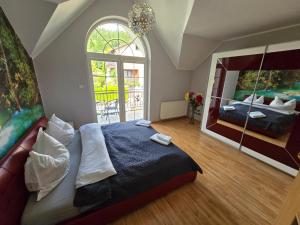 a bedroom with a large bed and a large window at Willa na Ogrodowej in Długopole-Zdrój