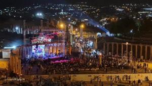 a crowd of people standing in front of a building at night at شاليه بانا جرش jerash in Khirbat ‘Uşfūr +69 photos