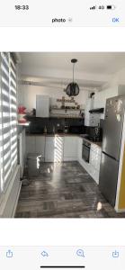 ルマンにあるChambre avec espaces communs-proche du circuit des 24hの白いキャビネットとステンレス製の冷蔵庫を備えたキッチン