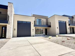 a large white house with two garage doors at Red Rock Views near Zion Bryce Grand Canyon Family and Friend Home in Kanab