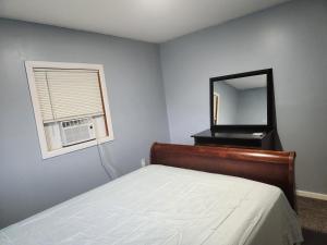 a bedroom with a bed with a mirror and a window at 2BR in Peaceful Country Near Ithaca in Willseyville